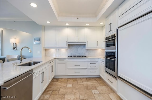 kitchen featuring stainless steel appliances, crown molding, sink, white cabinets, and tasteful backsplash