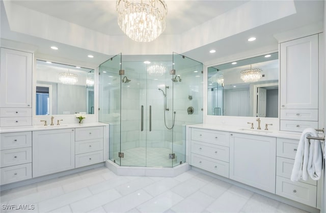 bathroom featuring vanity, tile patterned floors, a shower with shower door, and an inviting chandelier