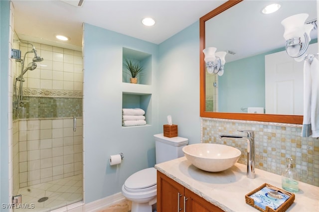 bathroom with vanity, toilet, tasteful backsplash, and walk in shower