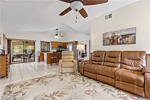 living room featuring lofted ceiling, ceiling fan, and light tile patterned floors