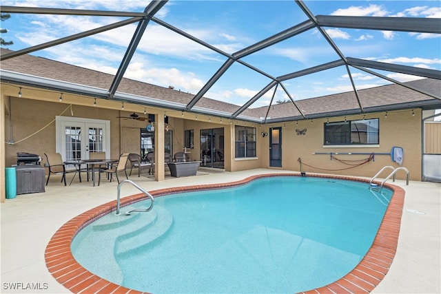 view of swimming pool with ceiling fan, a lanai, and a patio area