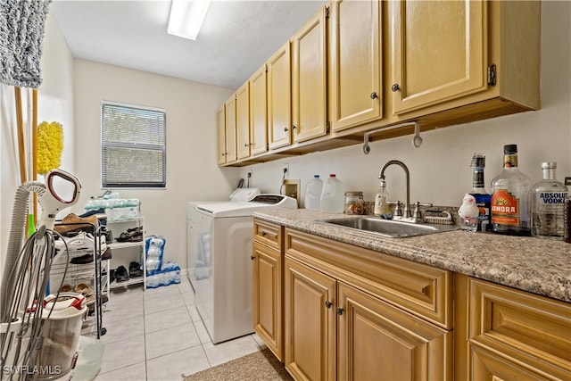 clothes washing area with cabinets, sink, washing machine and clothes dryer, and light tile patterned floors