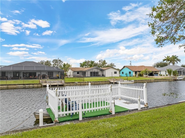 view of dock with a lanai, a yard, and a water view