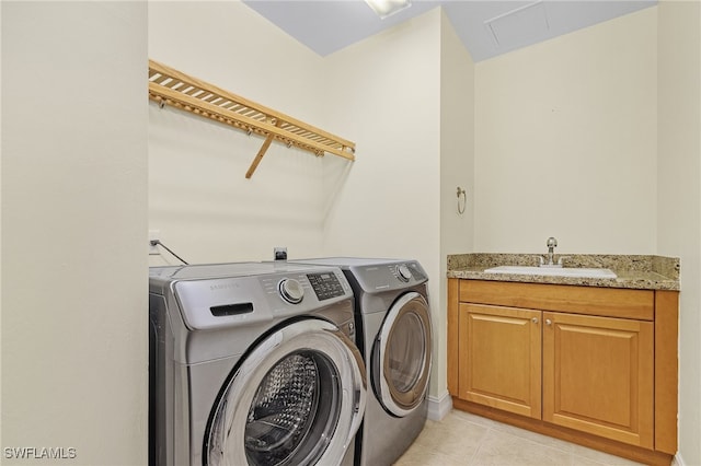 clothes washing area with cabinets, sink, light tile patterned floors, and washer and dryer