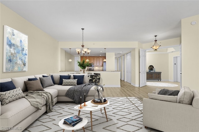 living room featuring light hardwood / wood-style floors and an inviting chandelier