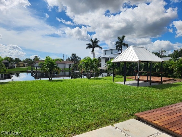 surrounding community with a water view, a gazebo, and a lawn