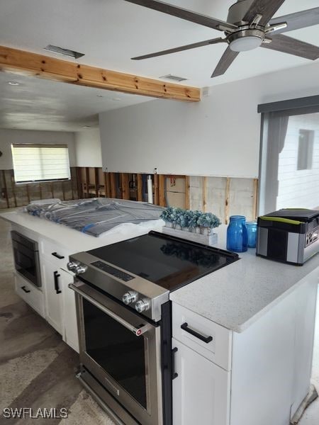 kitchen featuring built in microwave, ceiling fan, stainless steel electric stove, and white cabinets