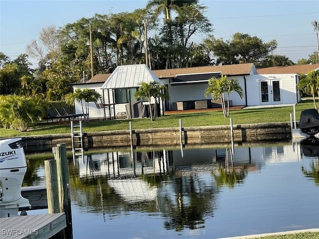 view of dock featuring a lawn and a water view