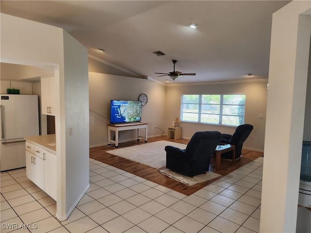 tiled living room featuring vaulted ceiling, ornamental molding, and ceiling fan