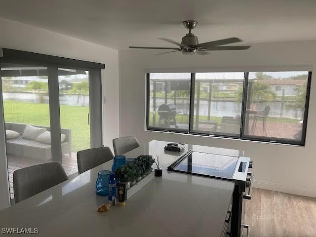 421 Cross St, North Fort Myers, FL 33903 - dining room with ceiling fan, a water view, wood finished floors, and baseboards