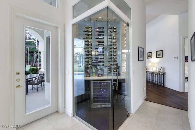 wine area with tile patterned flooring, wine cooler, and baseboards