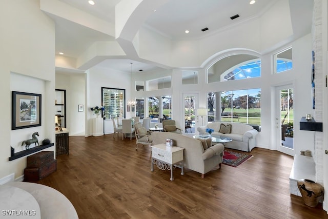 living area featuring dark wood finished floors, a towering ceiling, and baseboards