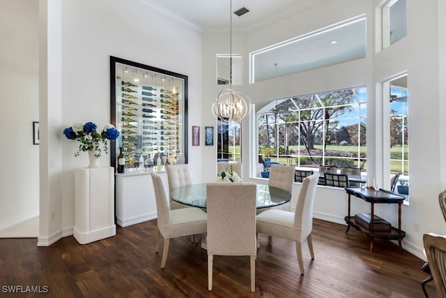 dining area with a notable chandelier, visible vents, ornamental molding, wood finished floors, and baseboards