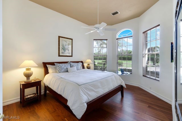 bedroom with dark wood-type flooring, visible vents, baseboards, and a ceiling fan