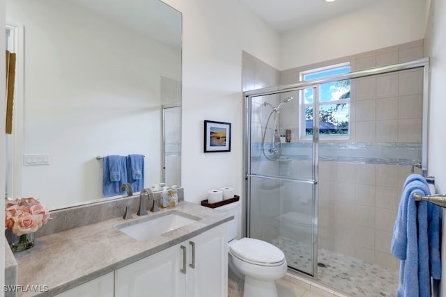 full bath featuring a stall shower, vanity, and toilet