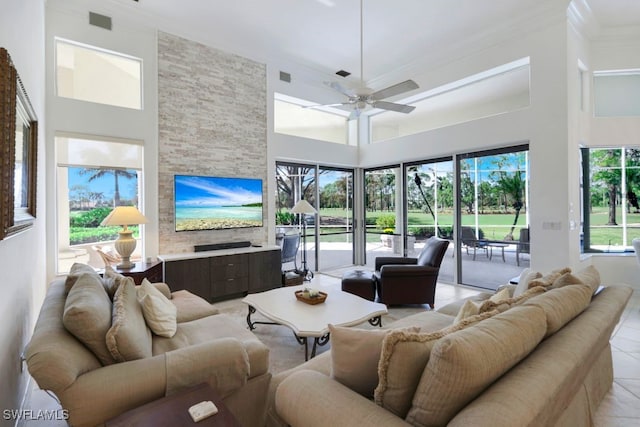 living area featuring a high ceiling, light tile patterned flooring, and a ceiling fan