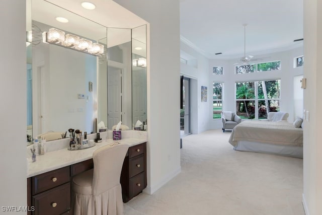 ensuite bathroom with ensuite bathroom, ceiling fan, vanity, baseboards, and ornamental molding