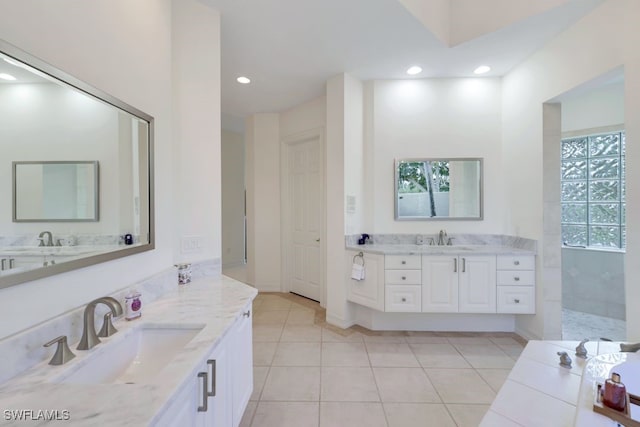 bathroom with tile patterned floors, two vanities, a sink, and recessed lighting