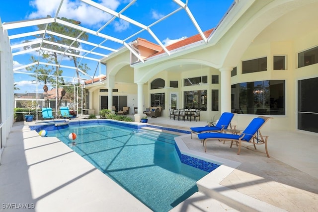 view of pool featuring a lanai, a pool with connected hot tub, and a patio