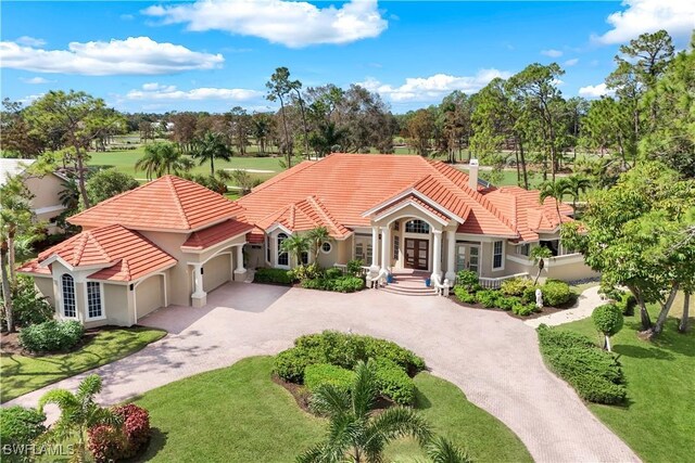 view of front of property featuring an attached garage, a tile roof, driveway, french doors, and stucco siding