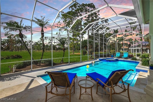 pool at dusk featuring glass enclosure and a patio area