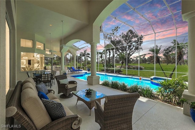 view of patio / terrace featuring a lanai, a pool with connected hot tub, an outdoor hangout area, and ceiling fan