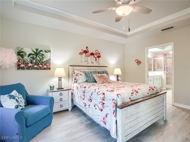 bedroom with ensuite bathroom, crown molding, ceiling fan, a tray ceiling, and wood-type flooring