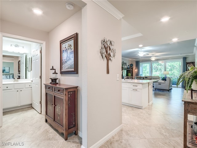 hallway with crown molding and sink