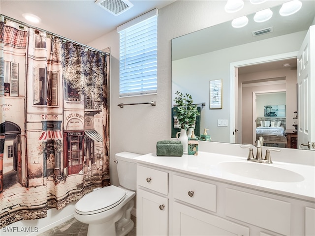 bathroom featuring tile patterned flooring, vanity, and toilet