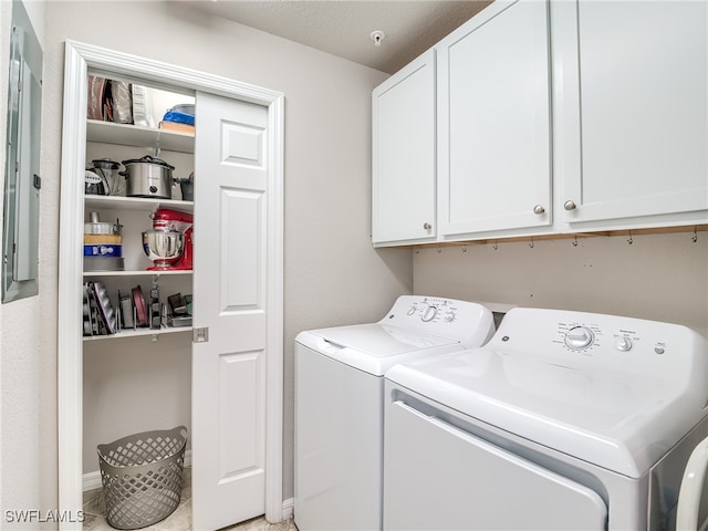 laundry room featuring washer and clothes dryer, cabinets, and a textured ceiling