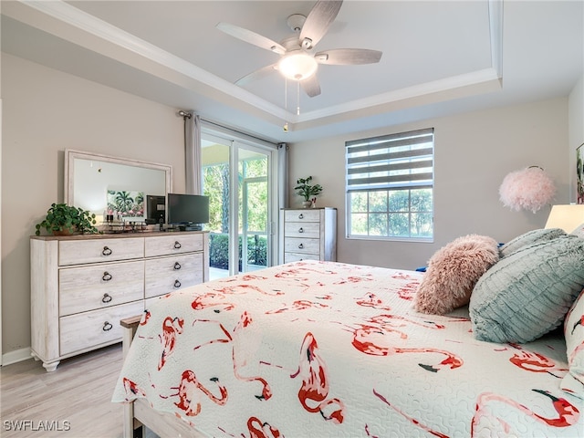 bedroom featuring a tray ceiling, ceiling fan, light hardwood / wood-style flooring, and access to outside