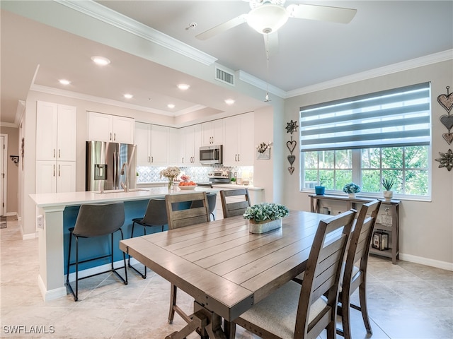 dining space featuring ceiling fan, sink, light tile patterned flooring, and ornamental molding