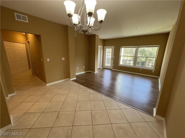 empty room with an inviting chandelier and light wood-type flooring