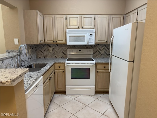 kitchen featuring light brown cabinets, tasteful backsplash, light stone counters, sink, and white appliances