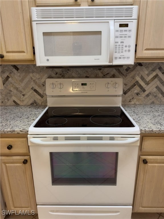 kitchen featuring backsplash, light brown cabinets, light stone counters, and white appliances