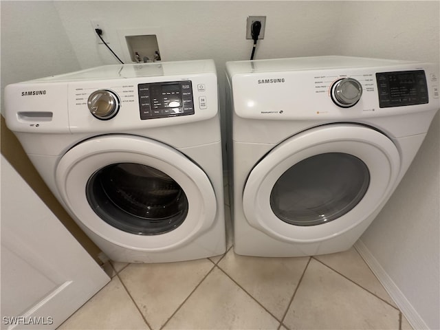 laundry area featuring light tile patterned flooring and washer and clothes dryer