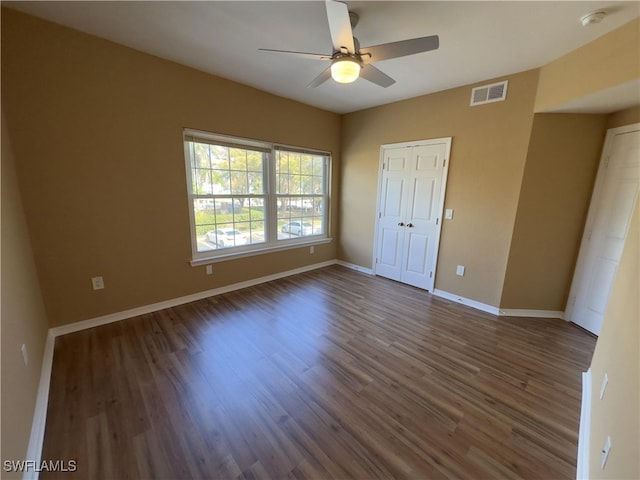 unfurnished bedroom featuring ceiling fan, a closet, and dark hardwood / wood-style flooring