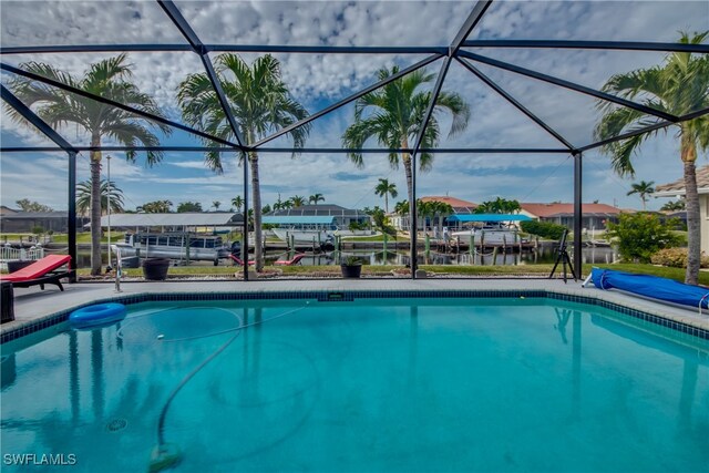 view of pool featuring glass enclosure and a water view