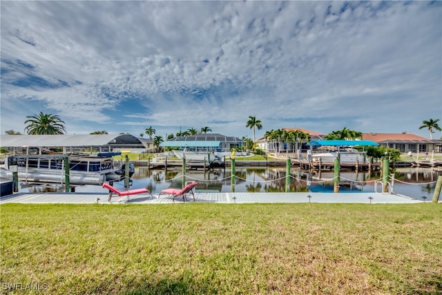 view of dock with a lawn and a water view