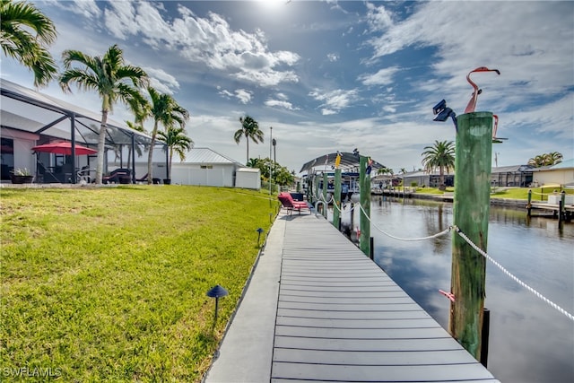 view of dock featuring a lanai, a water view, and a yard