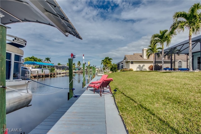 view of dock with a lawn, a water view, and a lanai