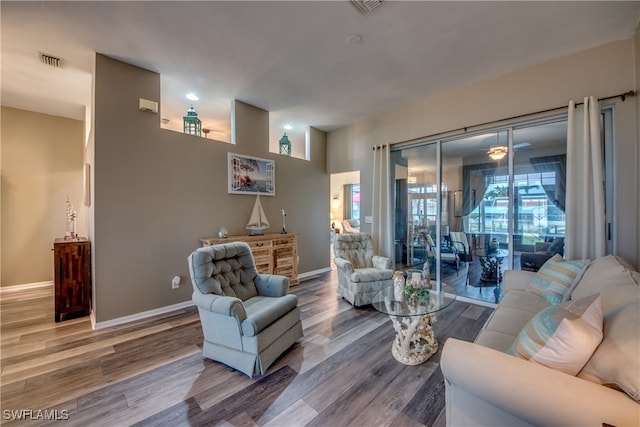 living room featuring wood-type flooring and ceiling fan