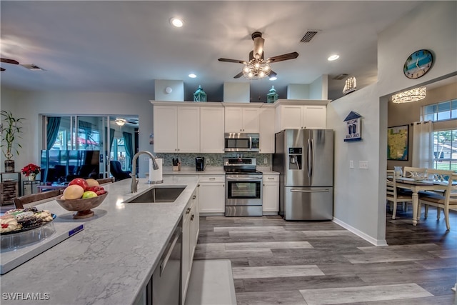 kitchen featuring sink, white cabinets, light wood-type flooring, and appliances with stainless steel finishes