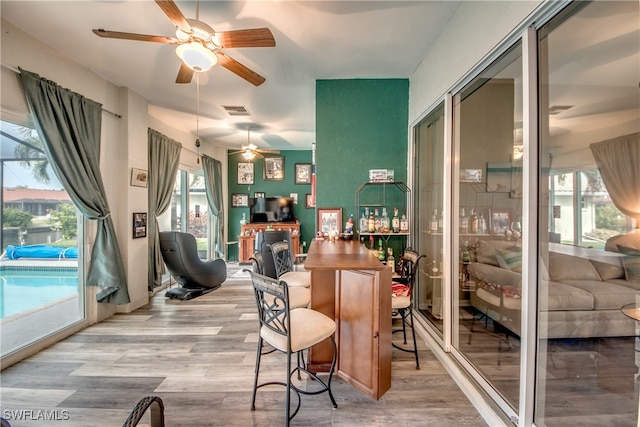 interior space with a fireplace, light wood-type flooring, and ceiling fan