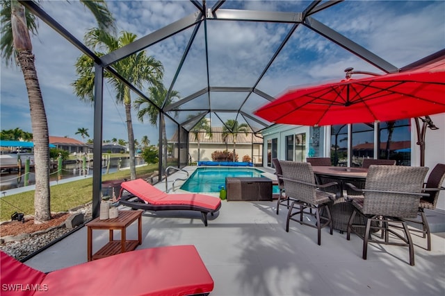 view of patio featuring glass enclosure and a water view