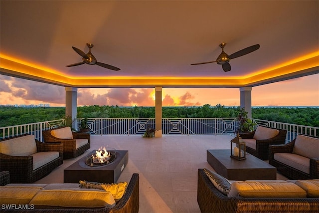 patio terrace at dusk featuring an outdoor living space with a fire pit and ceiling fan