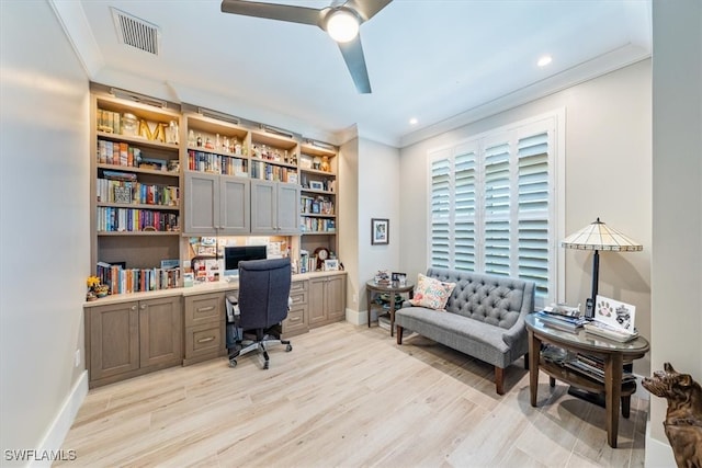 office space with ornamental molding, light hardwood / wood-style flooring, and built in desk