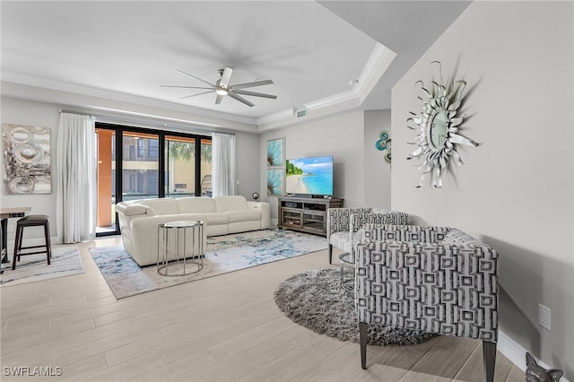 living room featuring ceiling fan, crown molding, and light hardwood / wood-style flooring