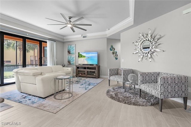 living room with light hardwood / wood-style flooring, ceiling fan, and crown molding