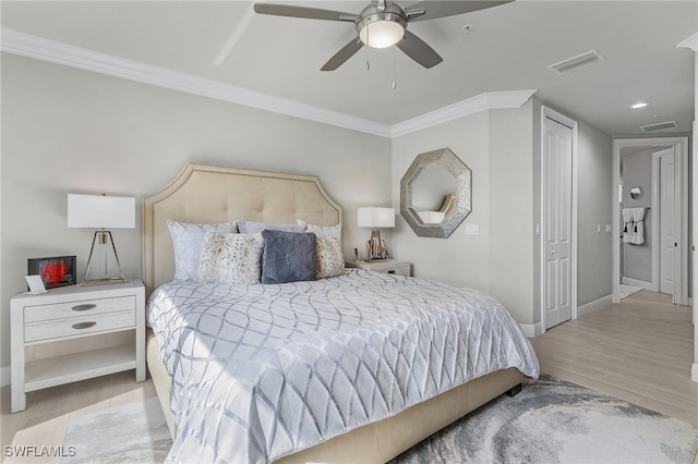 bedroom featuring a closet, ceiling fan, crown molding, and light hardwood / wood-style flooring